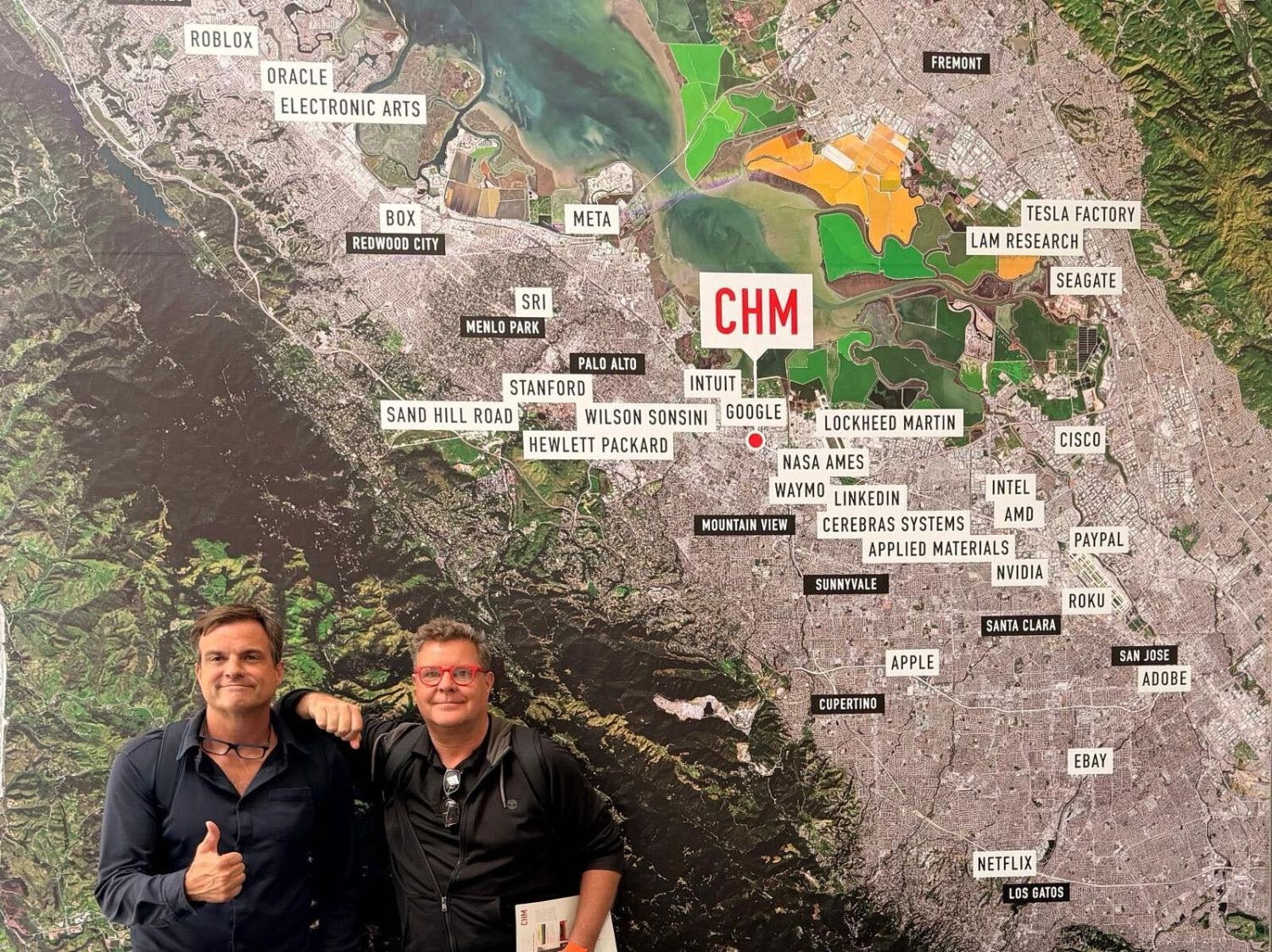 Sven Boermeester and Tom O'Malley standing in front of the Computer History Museum's aerial map of Silicon Valley, with Stanford, Sand Hill Road, Hewlett Packard, Google, NVIDIA, Apple and dozens of other names pinned across it.